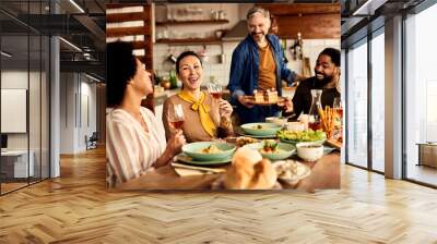 Multi-ethic group of friends having fun during a meal at dining table. Wall mural