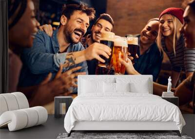 Multiracial group of happy friends has fun while toasting with beer in pub Wall mural