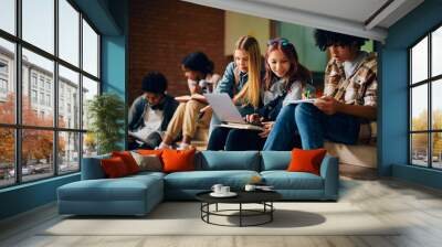 Multiracial group of high school students learning in hallway. Wall mural