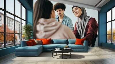 Muslim woman supporting new attender of group therapy to talk about herself during meeting at mental health center. Wall mural