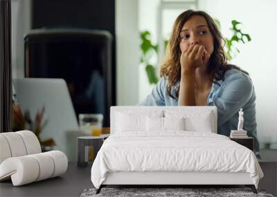 Pensive woman feeling worried while working on home finances. Wall mural