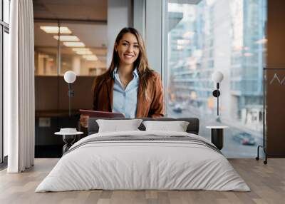 Portrait of happy businesswoman with touchpad in office looking at camera. Wall mural