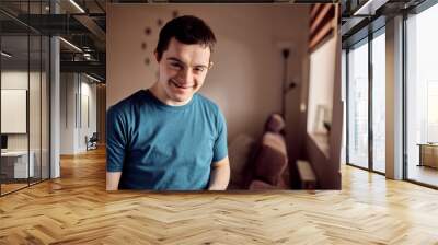 Portrait of happy man with down syndrome at home looking at camera. Wall mural