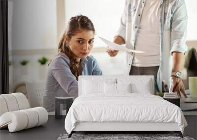 Sad businesswoman being scolded by her boss in the office. Wall mural