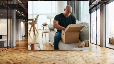 Surprised African American man opens cardboard box at home. Wall mural