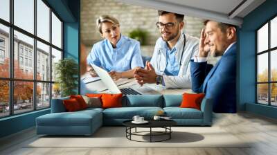 Team of doctors and businessman using computer during the meeting in the office. Wall mural