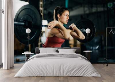 Young athletic woman having weight training in  gym. Wall mural