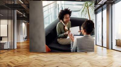 Young black businesswoman having consultations with her mentor in the office. Wall mural