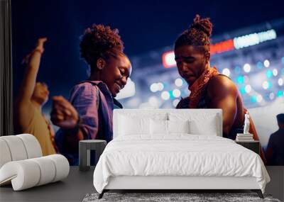 Young black couple dancing while enjoying in summer music festival at night. Wall mural