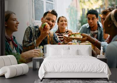 Young happy people having lunch together in Mexican restaurant. Wall mural