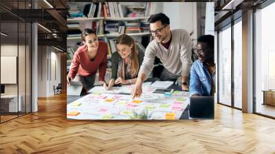 Young happy start up team analyzing mind map during business meeting in office. Wall mural