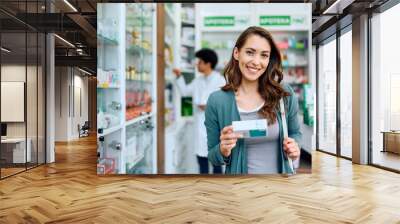 Young happy woman buying medicine in pharmacy and looking at camera. Wall mural