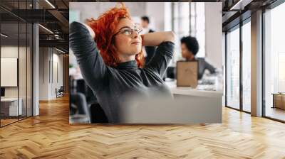 Young pensive businesswoman day dreaming in the office. Wall mural