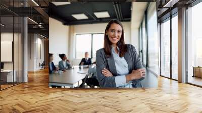 Young successful businesswoman at corporate office looking at camera. Wall mural