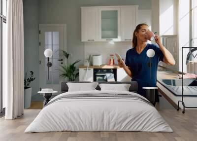 Young woman enjoying in cup of coffee after cleaning her home. Wall mural