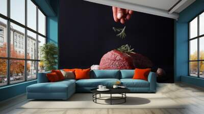 Cooking concept , man decorating raw beef meat with with rosemary close up. Wall mural