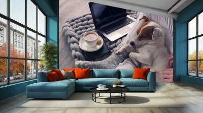 Woman in cozy home wear relaxing at home ,drinking cacao, using laptop. Soft, comfy lifestyle. Wall mural