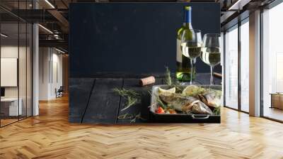 dinner concept for two. two glasses of white wine, baked fish. Wall mural