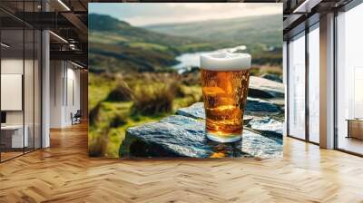 Glass of Irish refreshing beer on stone table with green mountains landscape. Enjoying scenic view of Ireland. Concept of rest after hiking trip. Banner, poster, greeting card with copy space.  Wall mural