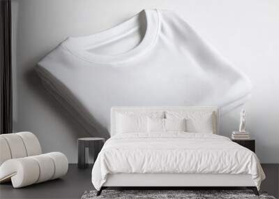 A folded white T-shirt on a white background, representing blank apparel for custom screen printing or graphic design. Wall mural