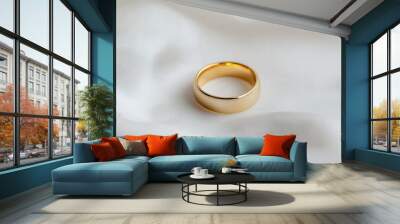 A gold wedding band placed on a pristine white background, perfect for showcasing jewelry and wedding concepts. Wall mural