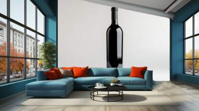 A sleek, dark bottle of red wine standing upright on a crisp white background, showcasing elegant wine packaging. Wall mural