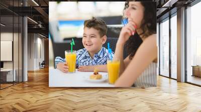 Boy and mother or happy family having healthy breakfast in resort cafe outdoor Wall mural