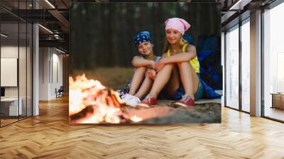 Tired and happy kids sitting at campfire Wall mural