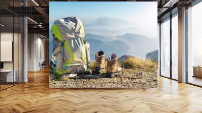 Hiking equipment. Backpack and boots on top of mountain Corno di Tres, Tresner Horn, Trentino, South Tyrol, Val di Non, Val d'Adige, Alps, Italy. Wall mural