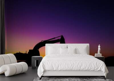 An industrial construction vehicle has been silhouetted against the rising sun. The significance shows the dawn on the new beginning that development can bring Wall mural