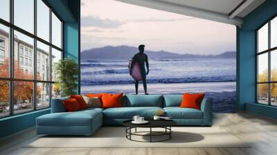 Silhouette of male surfer walking out of the ocean water in Costa Rica Wall mural