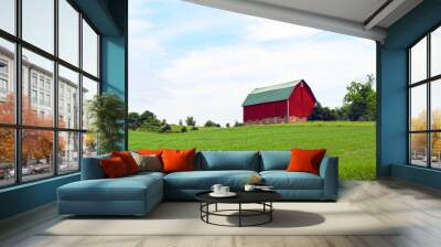 bright red farm barn building on a bright green pasture hillside under cloudy blue sky Wall mural