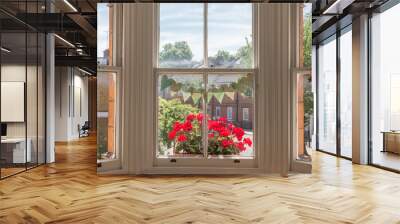 Interior of a Victorian British house with old wooden white windows  and red geranium flowers on the window sill facing a traditional English street Wall mural