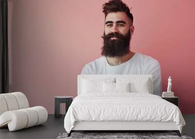 a stylish bearded man in casual attire, posing confidently against a soft pink background, radiating charm and suitable for highlighting text or graphic elements Wall mural