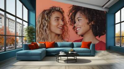 a woman with curly hair in a youthful casual look, chatting with a friend against a coral background, allowing for the incorporation of text or graphic elements Wall mural