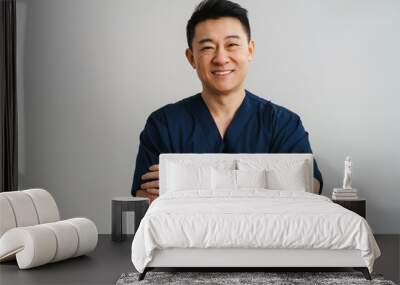 Adult asian man wearing medical uniform posing at camera Wall mural