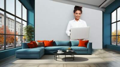 African cheerful business woman standing over grey wall Wall mural