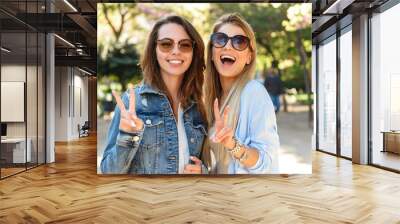 Amazing happy women friends outdoors showing peace gesture Wall mural