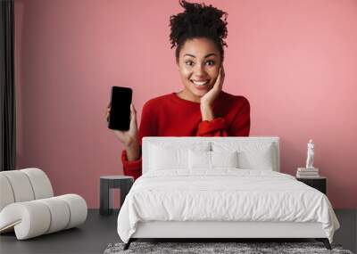 Amazing young african woman posing isolated over pink wall background showing display of mobile phone. Wall mural