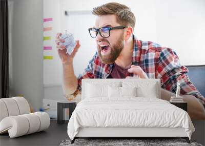 angry crazy designer yelling and crumpling paper on his workplace Wall mural