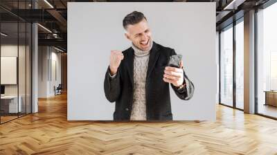 Attractive man wearing coat standing Wall mural