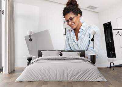 Attractive young african woman working on laptop computer Wall mural