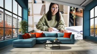 Attractive young girl student studying at the college library Wall mural