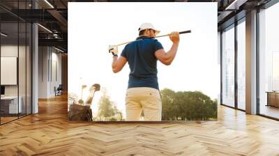 Back view of a male golf player at the course with a club sack Wall mural