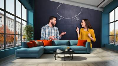 beautiful couple talking over blackboard background with speech bubble Wall mural