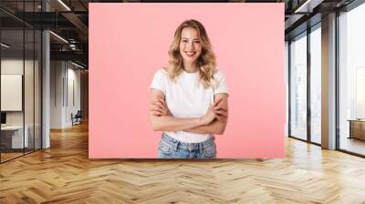 Beautiful young blonde woman posing isolated over pink wall background. Wall mural