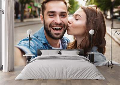 Beautiful young couple in love standing outdoors Wall mural