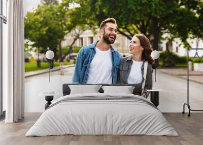 Beautiful young couple in love walking outdoors at the city street Wall mural