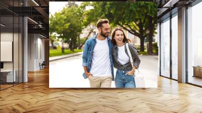 Beautiful young couple in love walking outdoors at the city street Wall mural