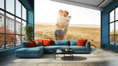 Beautiful young couple standing at the sunny beach Wall mural